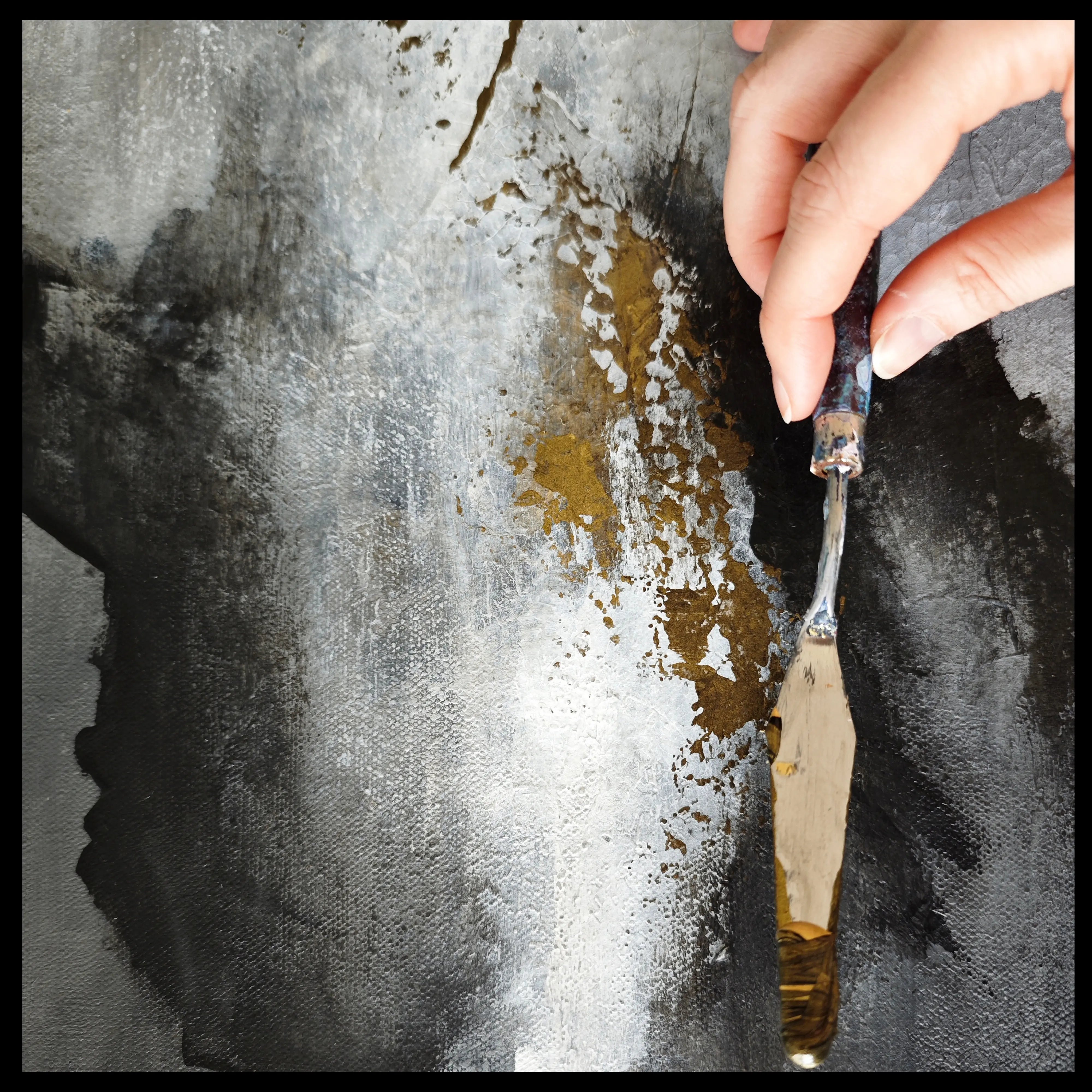 Close up on Anez Ka's abstract painting  - application of gold paint on a textured canvas.